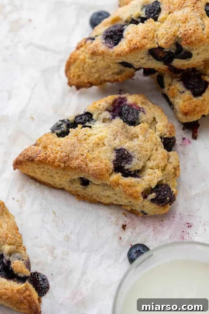 Homemade Starbucks blueberry scones, golden brown with a sugar topping and fresh blueberries visible.