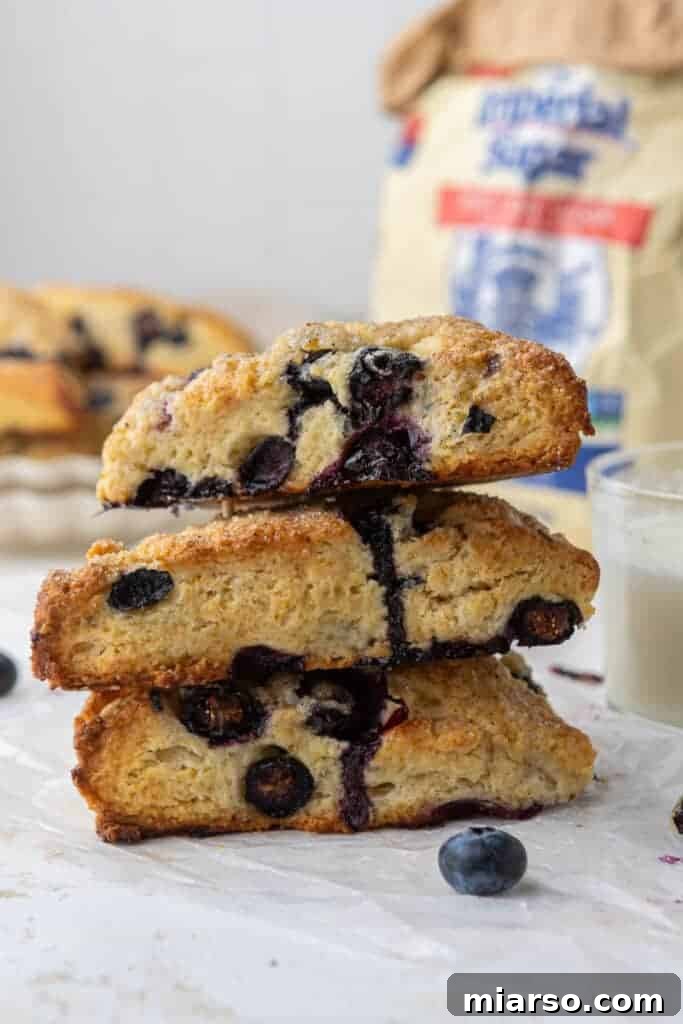 A stack of golden-brown blueberry scones on a cooling rack.