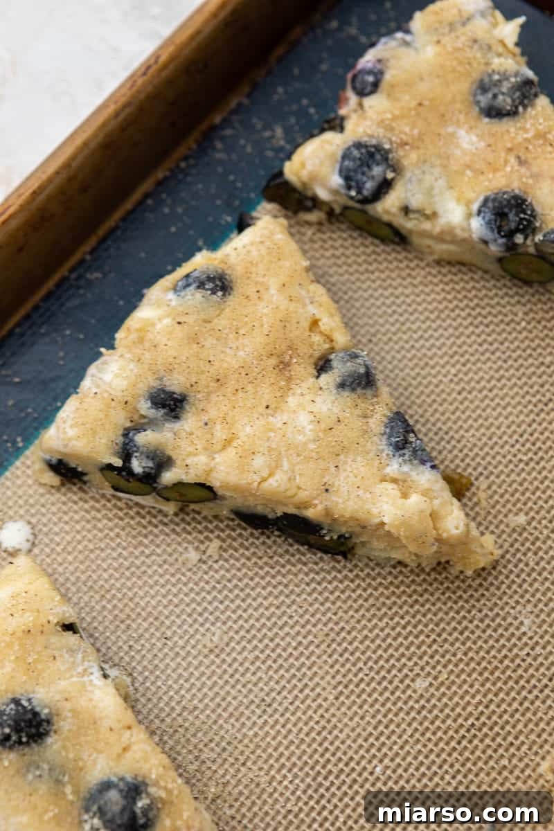 Raw scone dough triangles with granulated sugar sprinkled on top