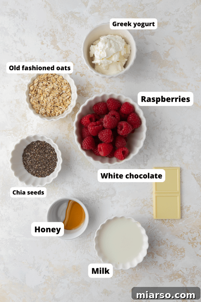 Individual ingredients for white chocolate raspberry overnight oats laid out on a surface.