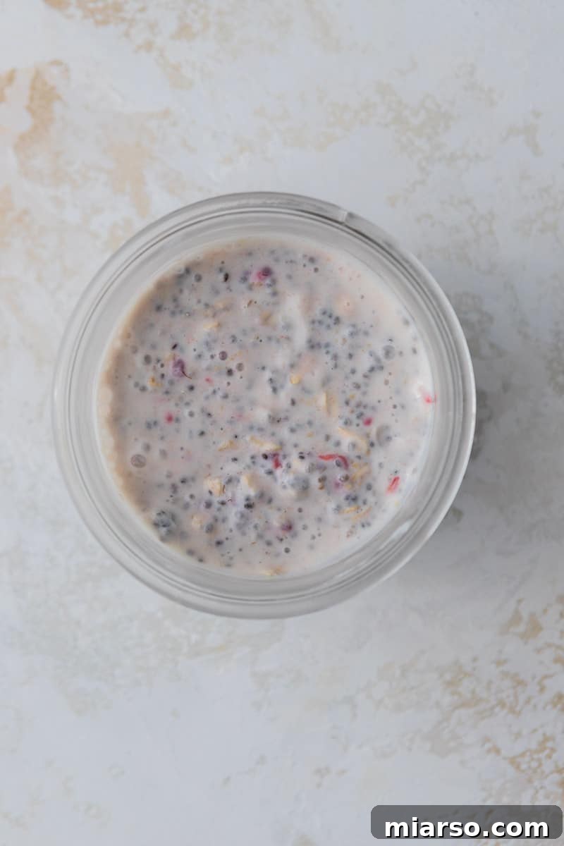 Overnight oats mixture in a cup before adding chocolate topping.