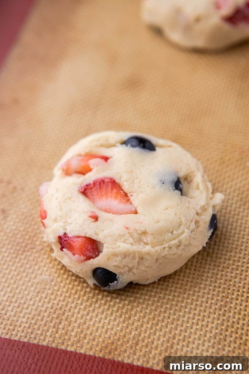 Flattened berry cookie dough ready for baking on parchment paper
