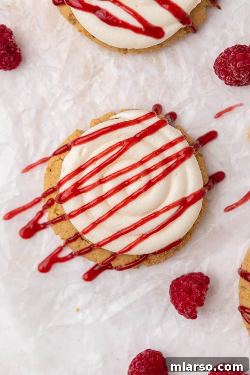 Close-up of baked Crumbl Raspberry Cheesecake Cookies, showing their thick, round shape before frosting.