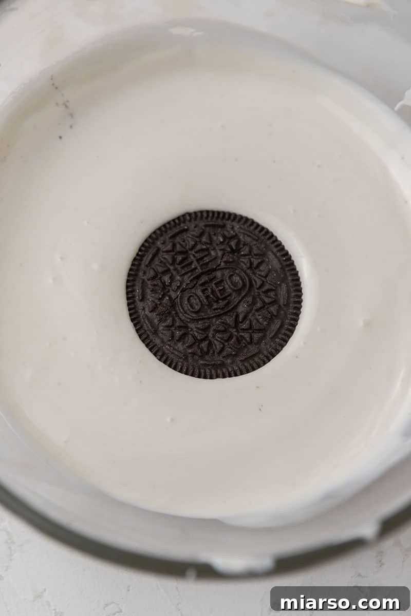 Red, White, & Blue Oreo Delights 5 Oreo being dipped into melted white chocolate, showing the smooth coating process.
