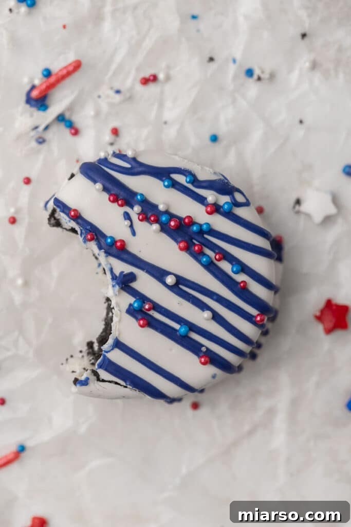 Red, White, & Blue Oreo Delights 9 A red, white, and blue chocolate covered Oreo with a bite taken out, showing the delicious layers.