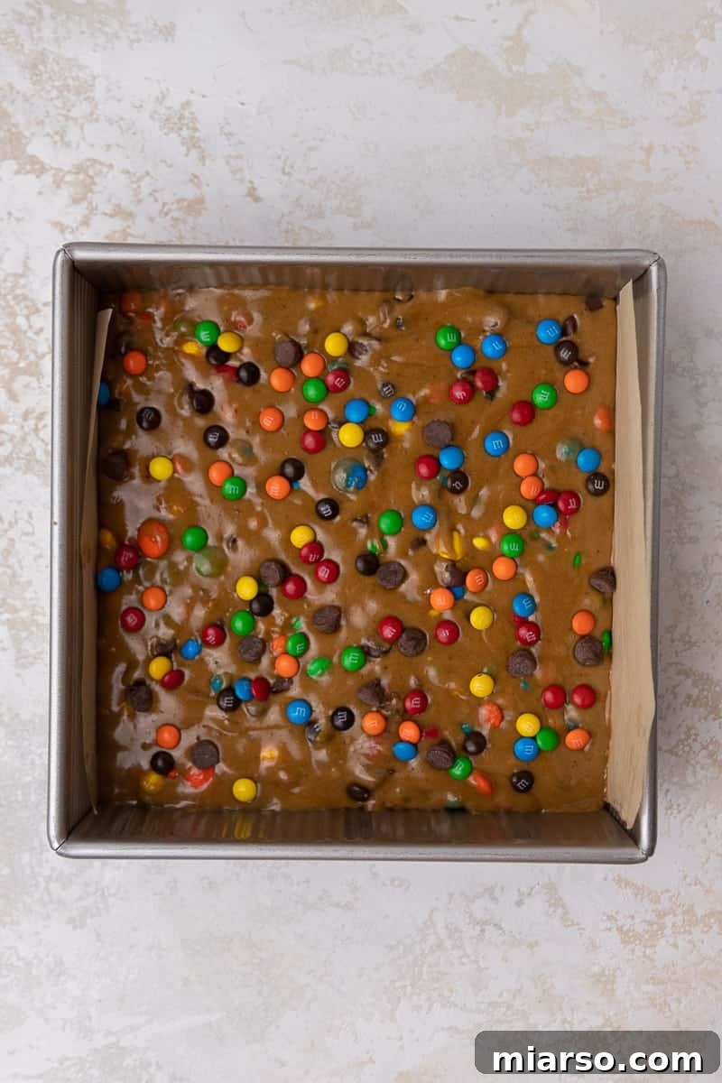 8x8 baking pan with M&M's blondies inside before baking