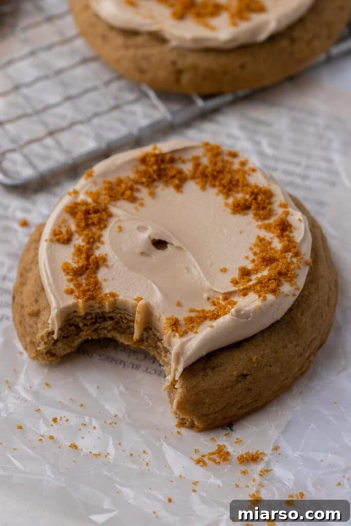 Crumbl Cookie Butter Cookie Crunch Ice Cream 11 Cookie butter cookie with a bite taken out, showing the soft cookie and creamy frosting