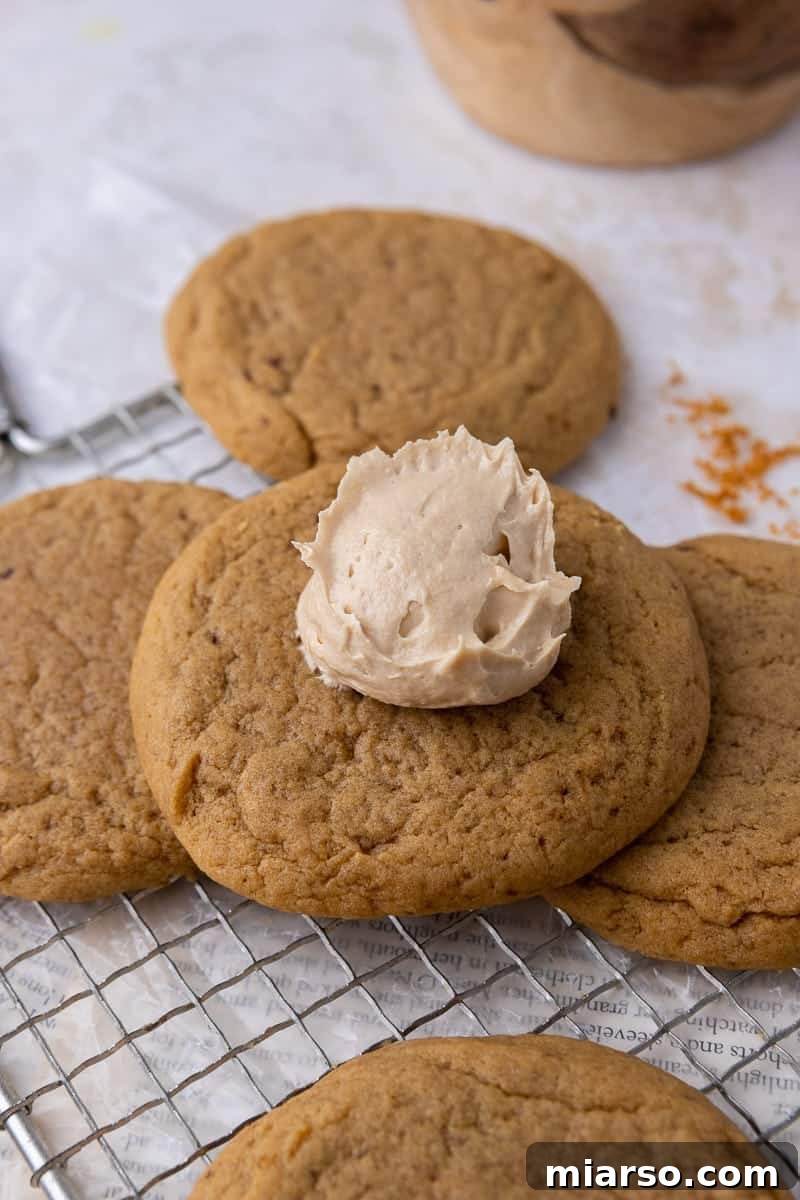 Crumbl Cookie Butter Cookie Crunch Ice Cream 9 A cookie with a dollop of creamy cookie butter buttercream on top, before spreading