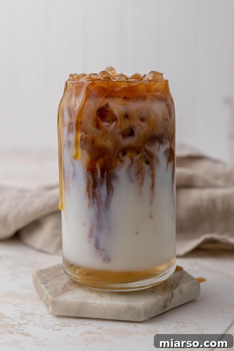 Starbucks Inspired Homemade Iced Caramel Macchiato 6 Finished iced caramel macchiato with distinct layers of milk, espresso, and a caramel drizzle.