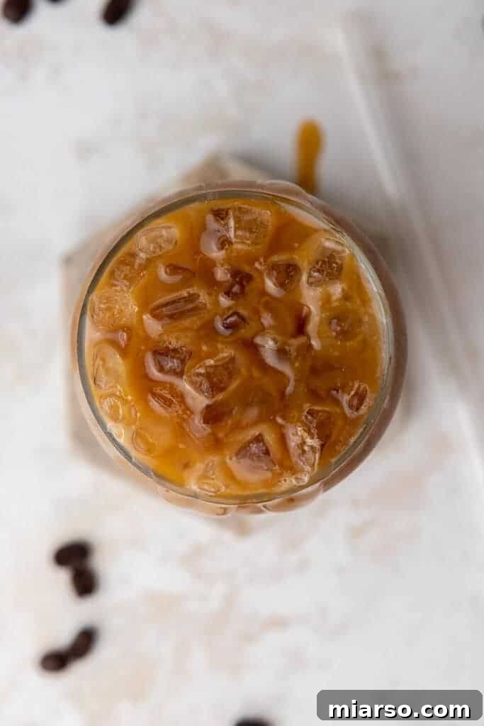 Starbucks Inspired Homemade Iced Caramel Macchiato 7 Overhead shot of a refreshing iced coffee drink in a clear glass.