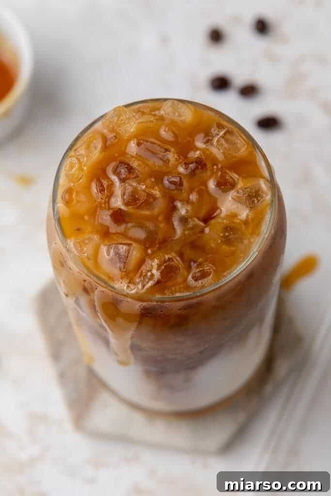 Starbucks Inspired Homemade Iced Caramel Macchiato 9 A popular Starbucks summer drink, iced caramel macchiato, presented in a clear to-go cup.