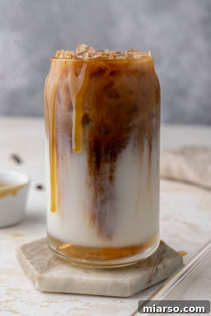 Starbucks Inspired Homemade Iced Caramel Macchiato 10 A beautifully crafted Starbucks caramel iced macchiato in a clear glass, ready to be enjoyed.