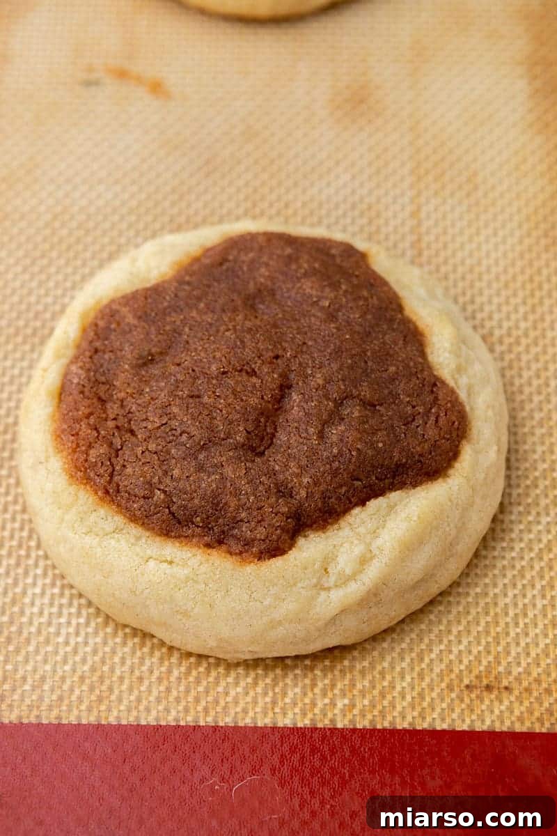 Baked cinnamon roll cookies cooling on a rack