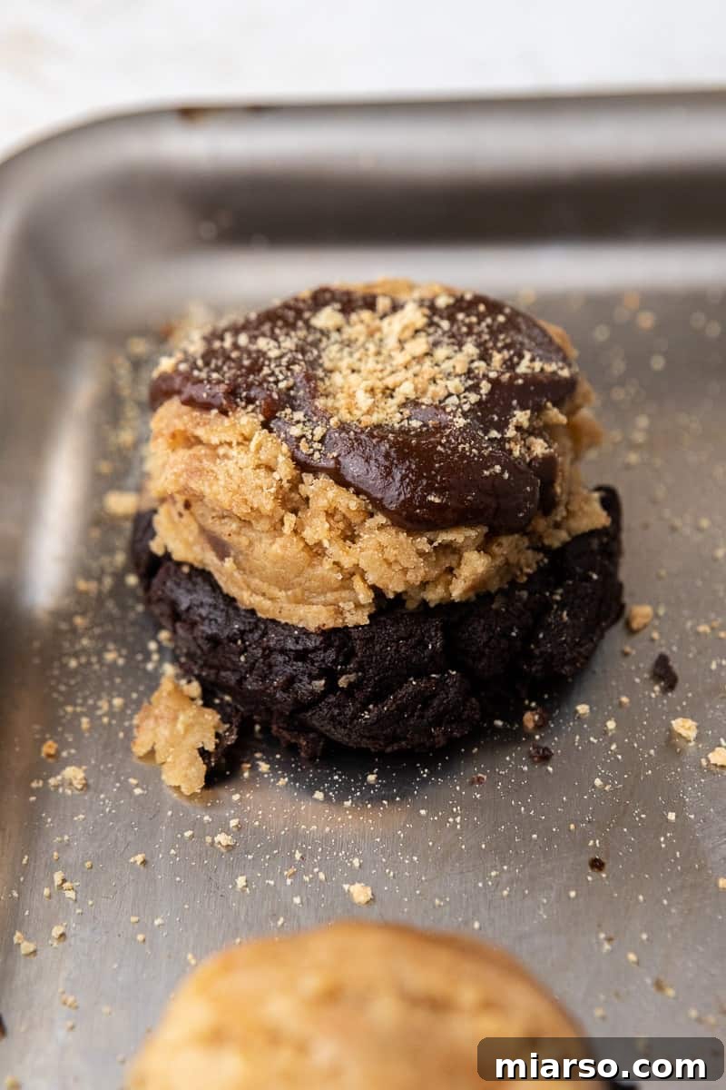Crumbl S'mores brownie cookies dough assembled with brownie batter and crumbs