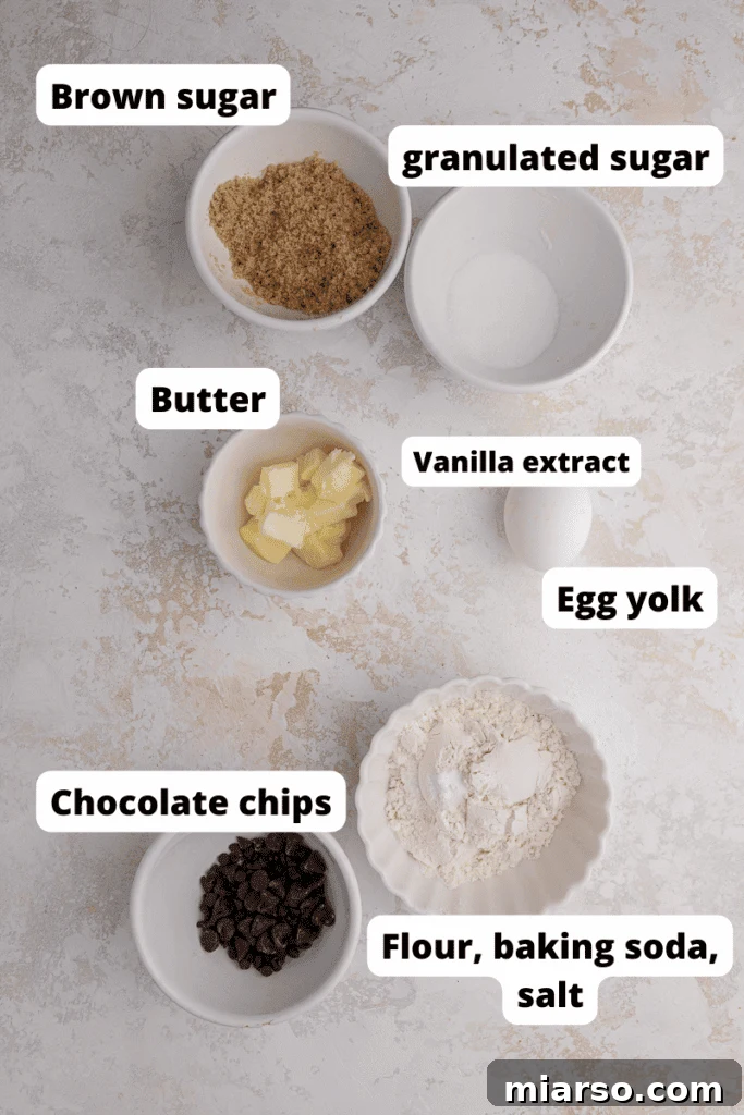 Unlock the Secret to Your Perfect Single Serve Chocolate Chip Cookie 3 Ingredients laid out for a single serve chocolate chip cookie recipe including butter, sugars, egg yolk, flour, vanilla, salt, baking soda, and chocolate chips.