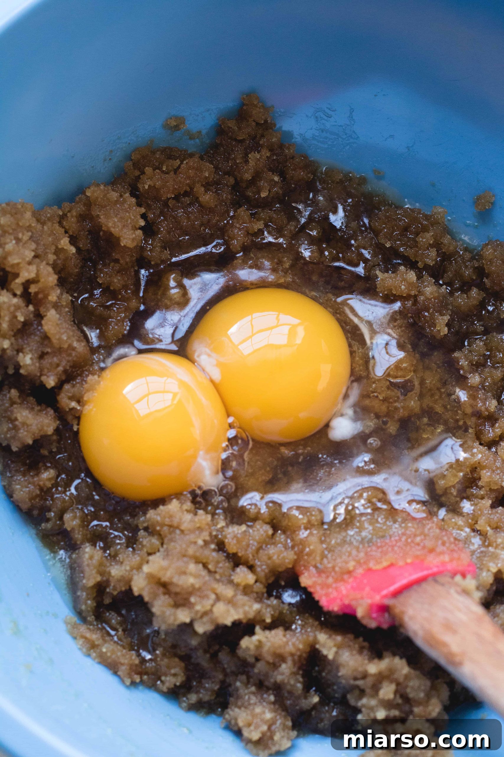 Mixing brown sugar with cooled brown butter and eggs for blondie batter.