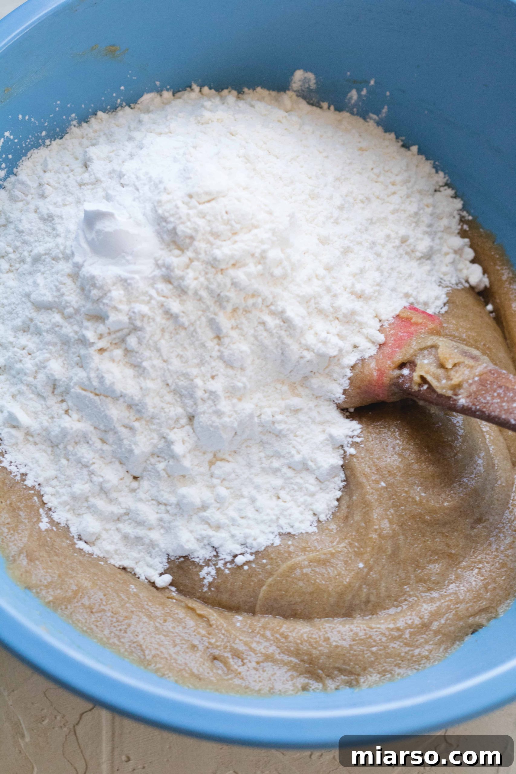 Adding flour to the brown butter blondie wet mixture, ready for gentle mixing.