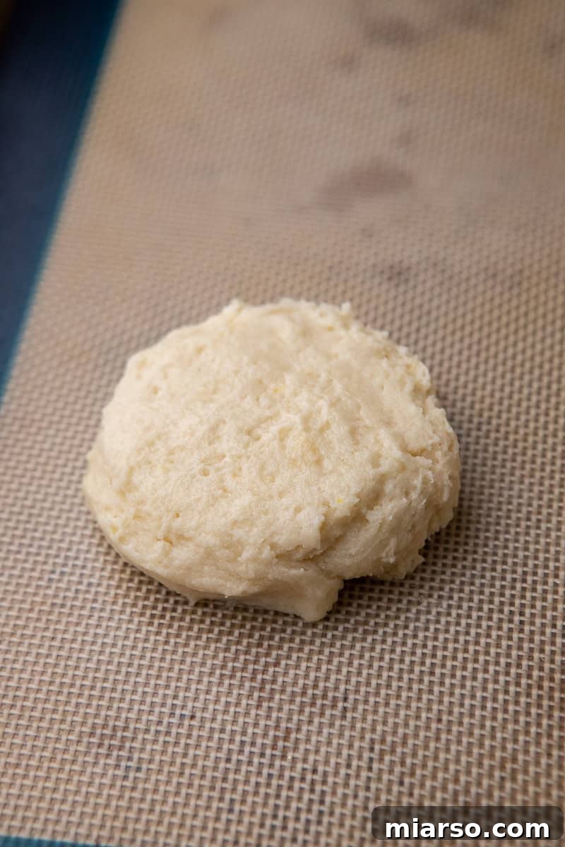 Cookie dough balls on a baking sheet lined with parchment paper, flattened slightly