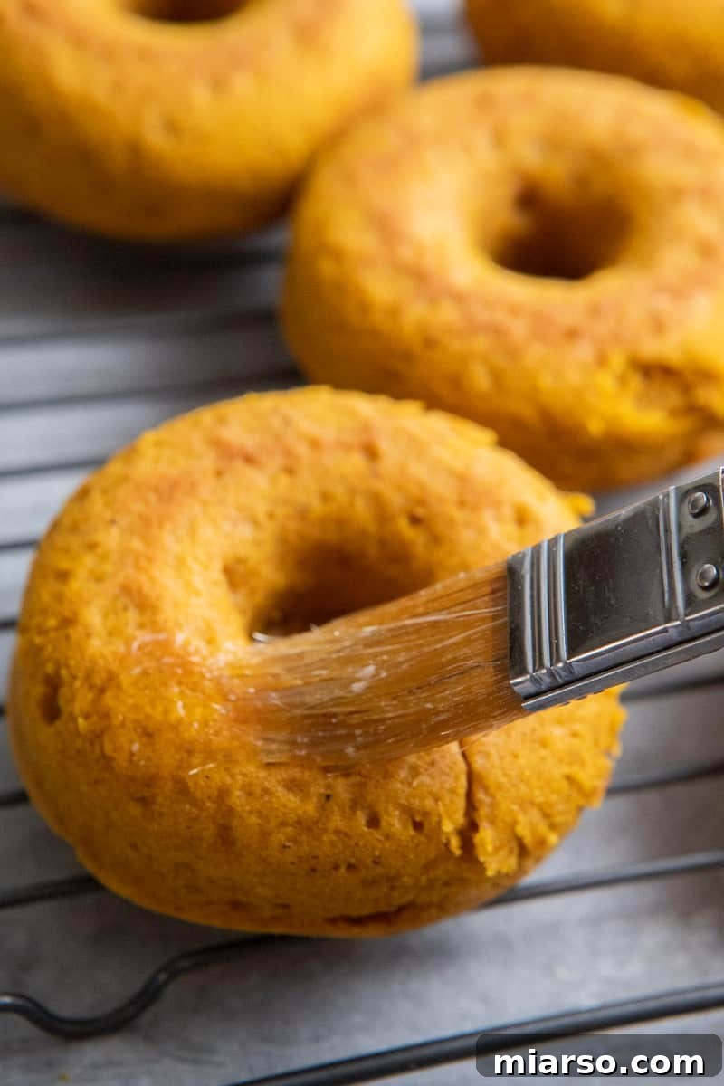 Decadent Pumpkin Spice Donut Perfection 8 Brushing melted butter on donut