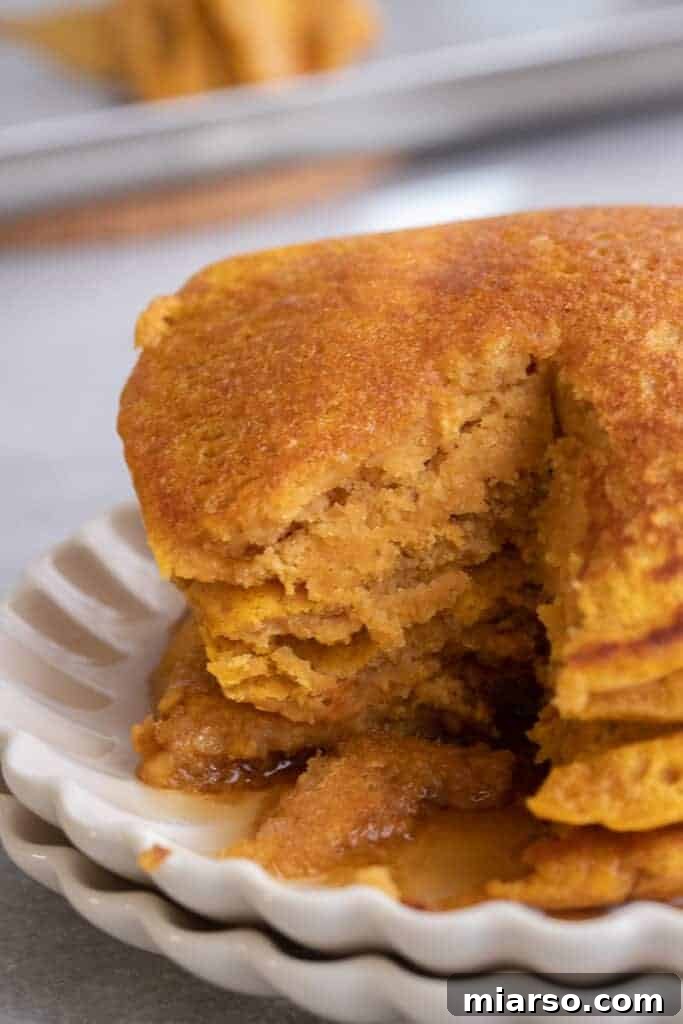 Pumpkin pancakes made with pancake mix stacked high on a plate