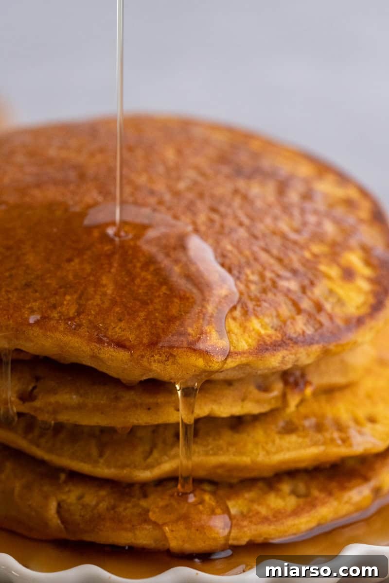 Fluffy pumpkin pancakes cooking on a griddle