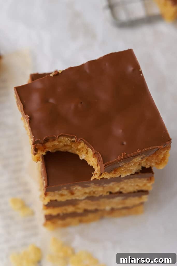Stack of freshly made Scotcheroos with a thick, glossy chocolate and butterscotch topping, ready to be served.
