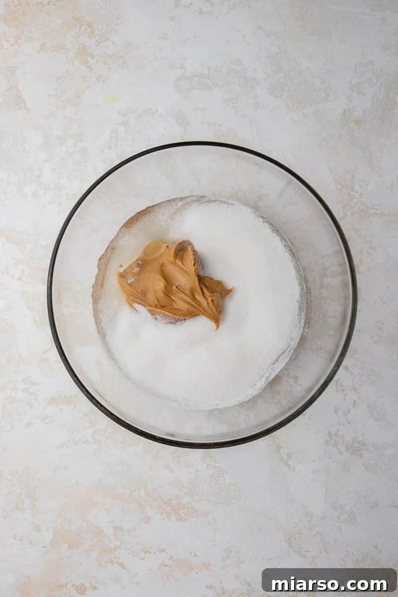 Bowl with melted light corn syrup, granulated sugar, and peanut butter mixture.