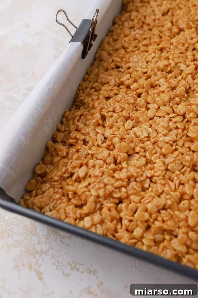 Rice Krispies cereal thoroughly coated in the peanut butter and syrup mixture.