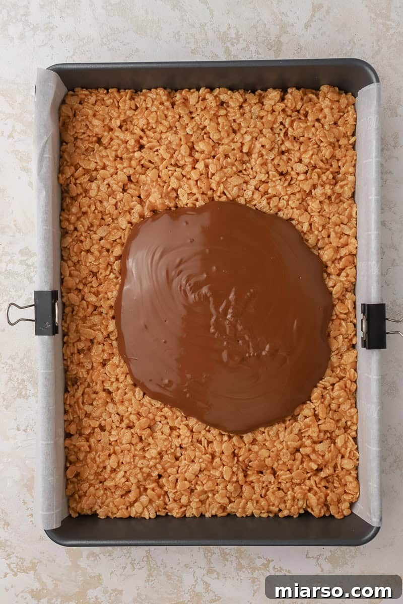 Scotcharoos base mixture pressed evenly into a 9x13 inch pan.