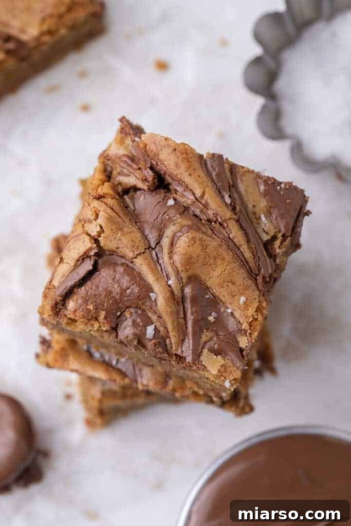 Decadent Nutella Swirl Blondies 2 Stack of luscious Nutella swirl blondies, perfectly baked with golden edges and rich hazelnut chocolate swirls
