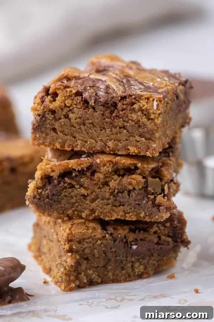 Decadent Nutella Swirl Blondies 4 A stack of golden brown butter Nutella blondies, showcasing their chewy texture and beautiful swirls