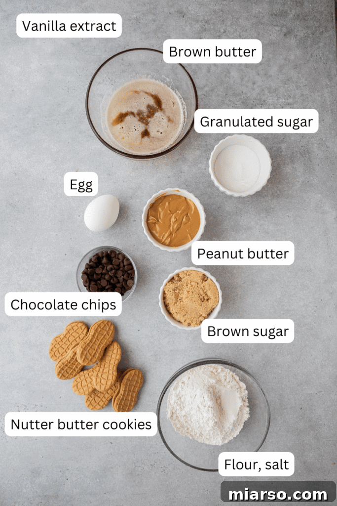 Various baking ingredients, including butter, sugars, peanut butter, and Nutter Butter cookies, laid out on a kitchen countertop.