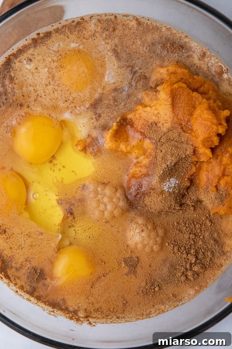 Wet ingredients for pumpkin crunch cake in a mixing bowl