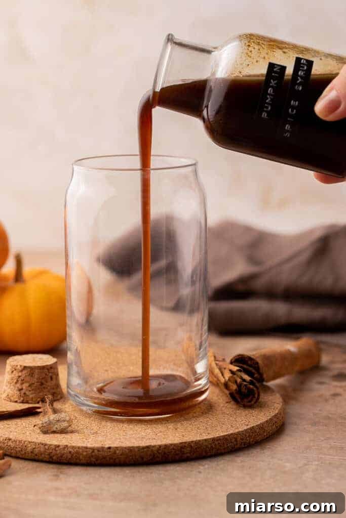 Hand pouring syrup in cup