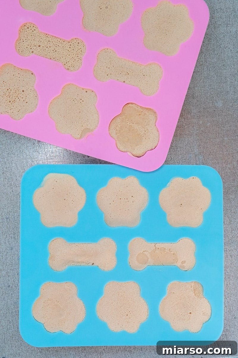 Frosty Peanut Butter Banana Pupsicles 7 Treat mixture being poured into paw-shaped puppy molds