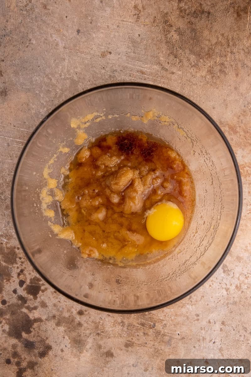 Wet ingredients mixed with sugars in a bowl for brownies