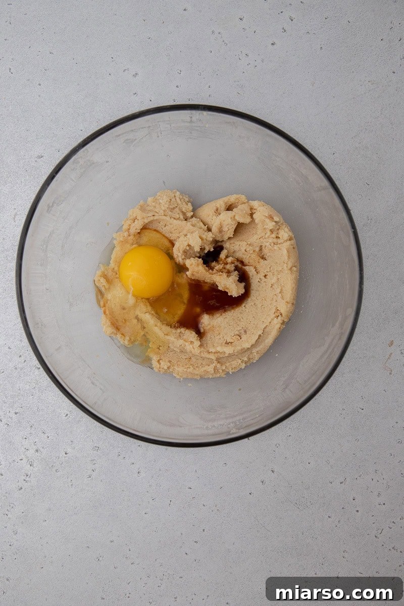 Wet ingredients (butter, sugar, egg, vanilla) being mixed in a bowl.