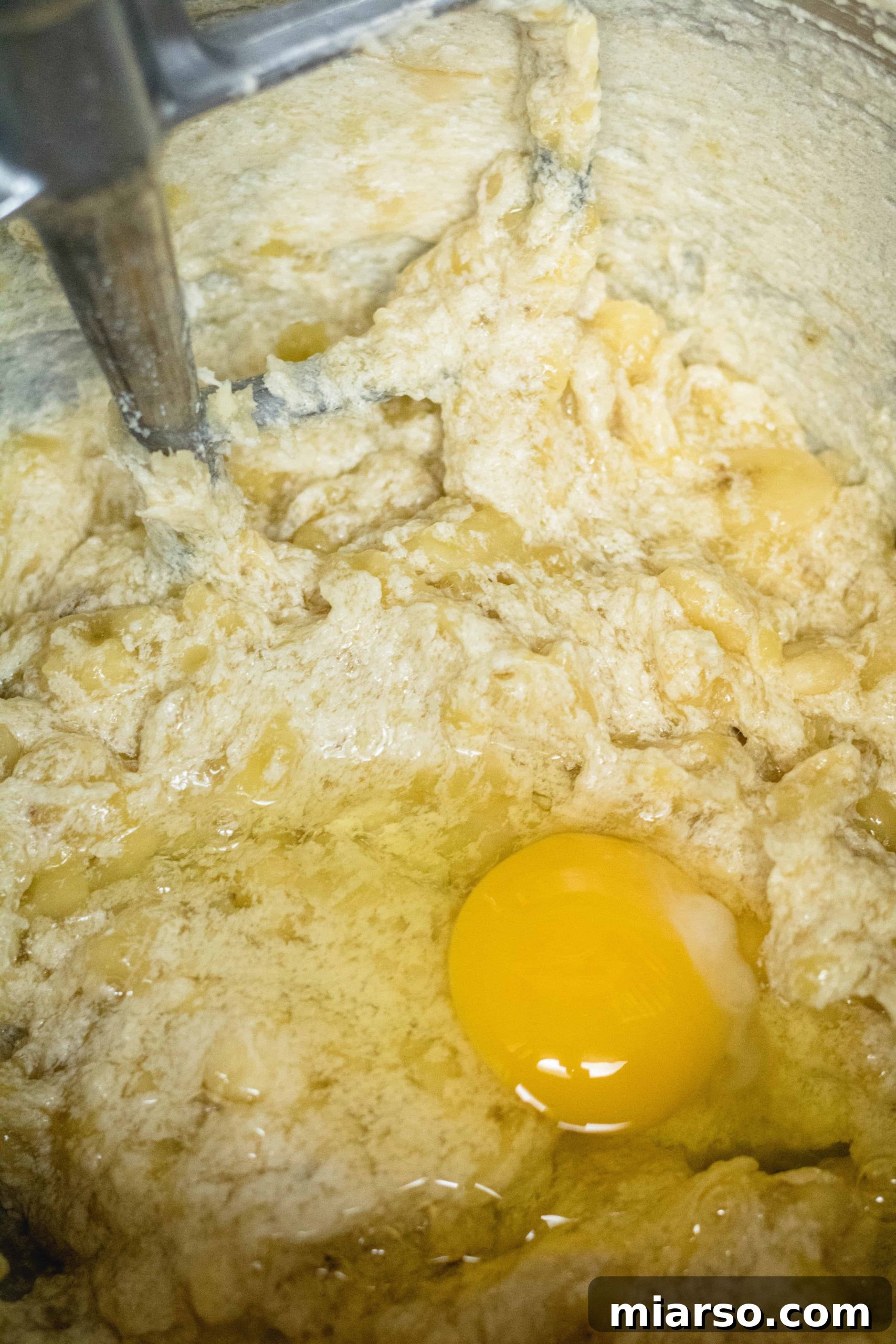 Bakery-Style Banana Walnut Muffins 13 Adding a large egg to the banana muffin mix in a stand mixer