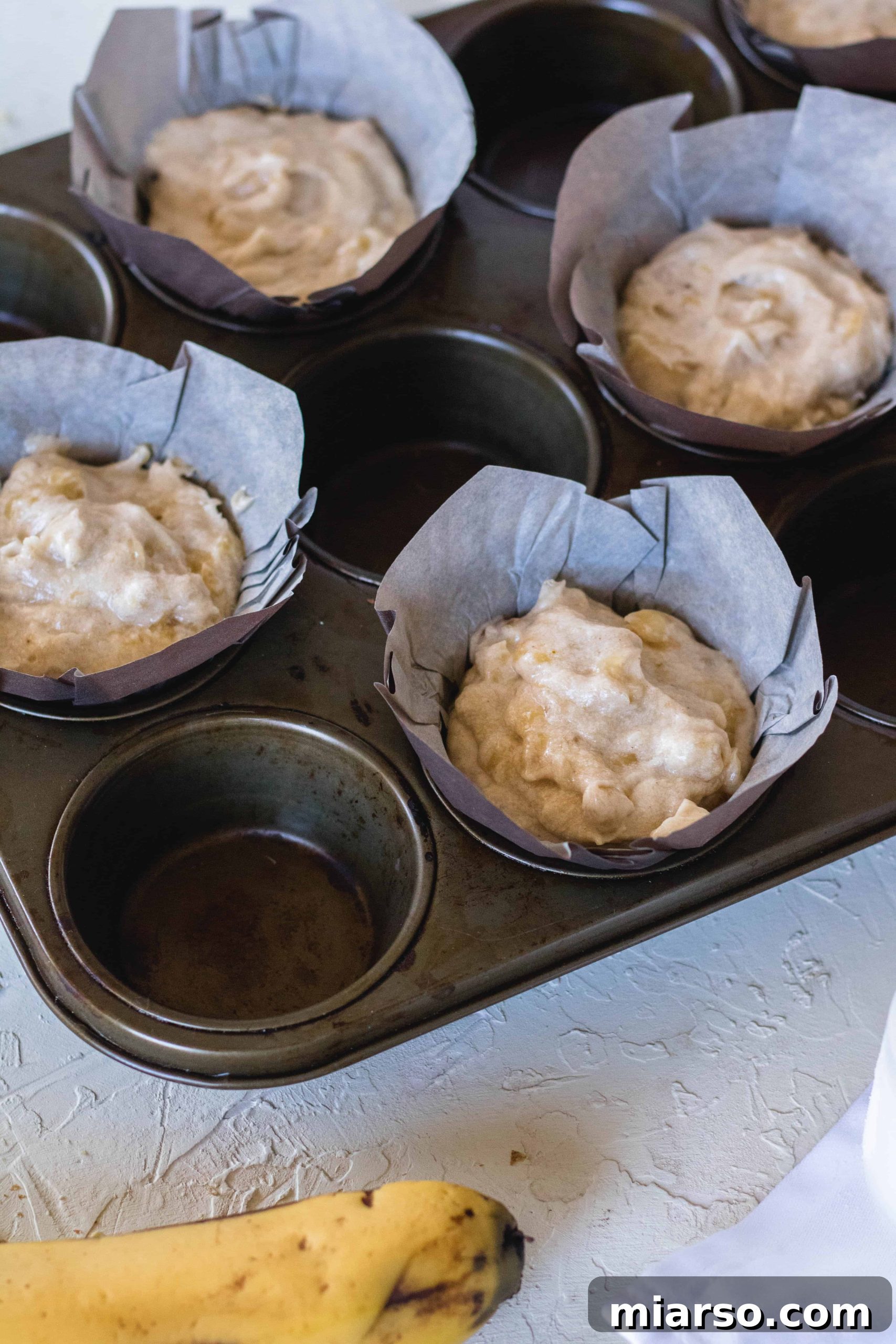 Bakery-Style Banana Walnut Muffins 17 Banana nut muffin batter scooped into 10 large muffin liners, ready for the oven