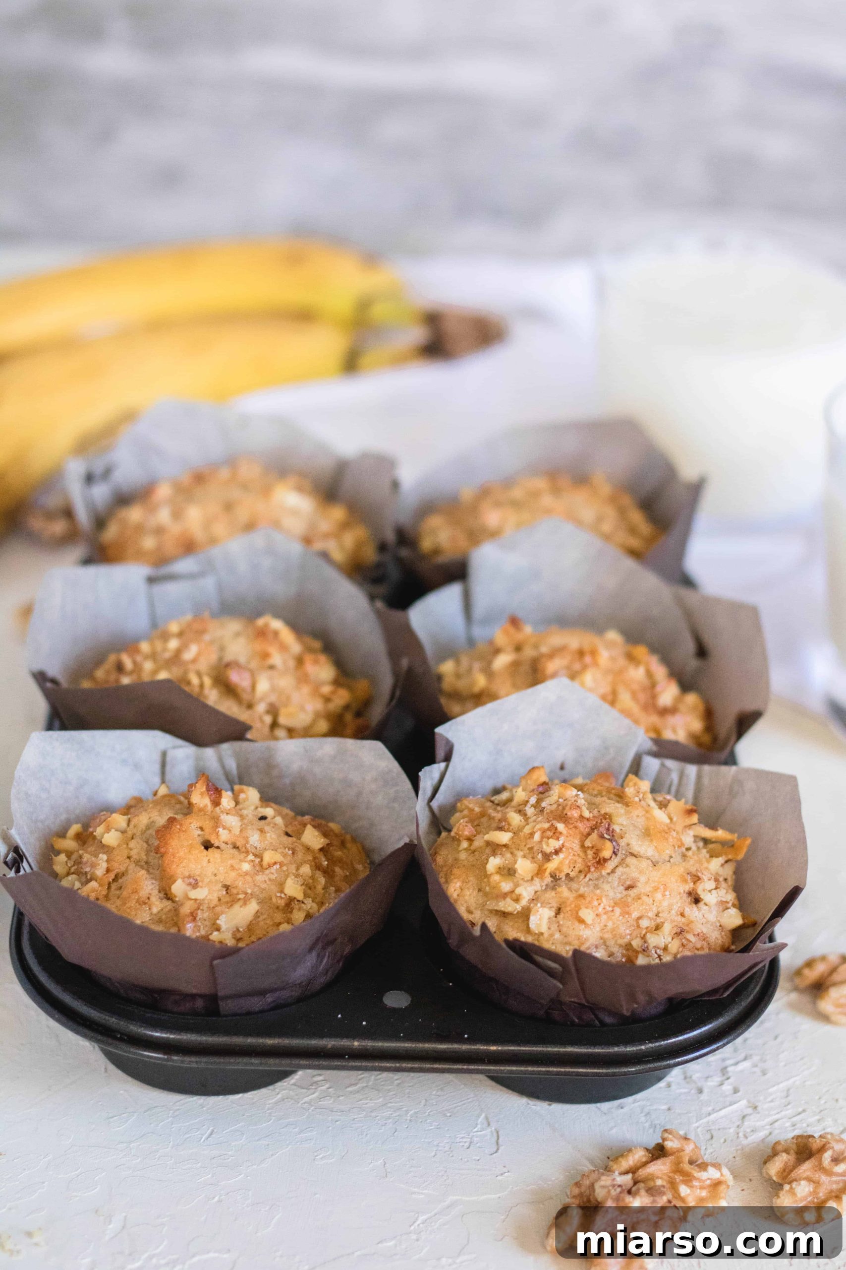 Bakery-Style Banana Walnut Muffins 19 Freshly baked banana nut muffins cooling on a wire rack after being removed from the oven