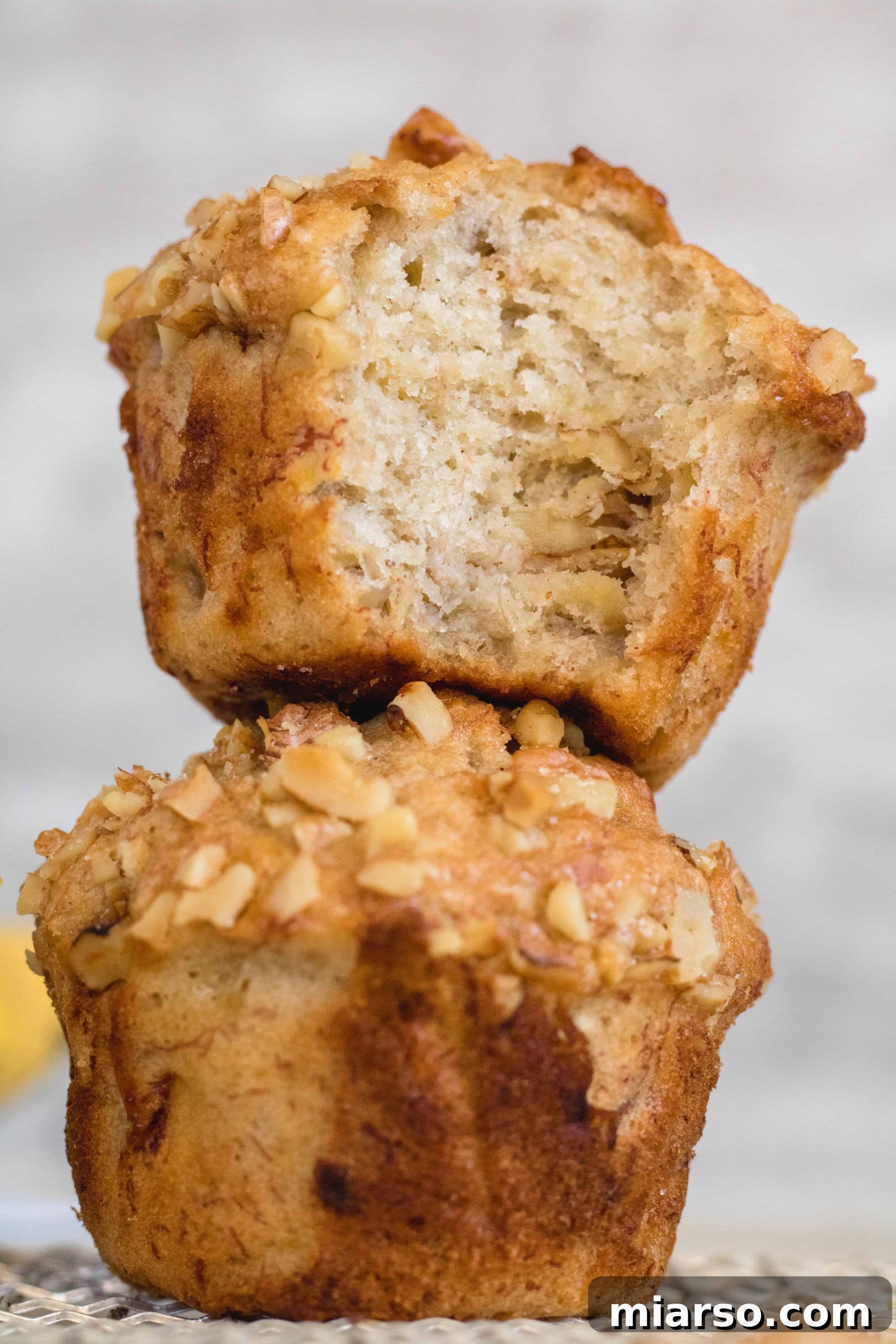 Bakery-Style Banana Walnut Muffins 3 Close-up of tall, fluffy high banana walnut muffins with visible nuts, showing their appealing texture