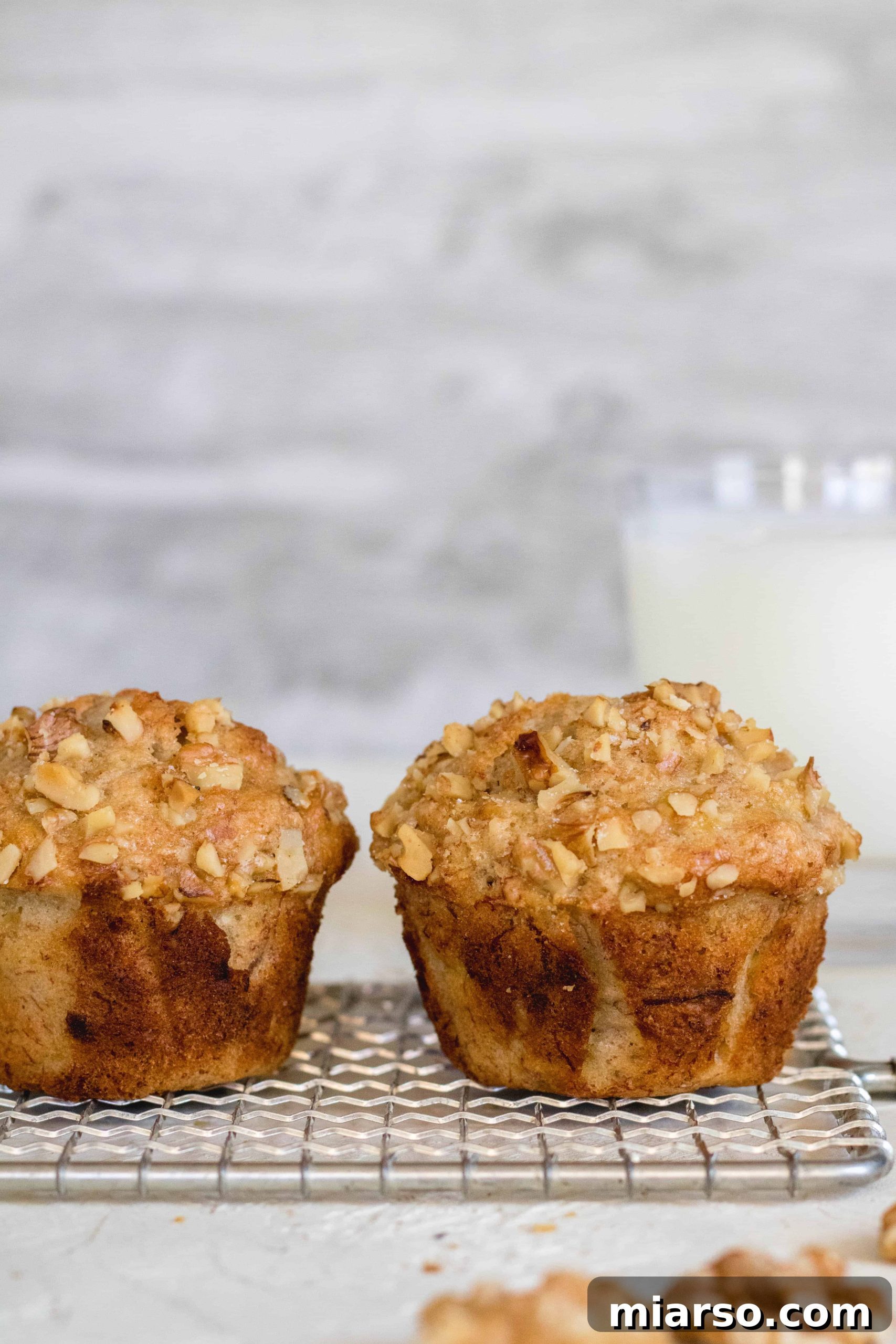 Bakery-Style Banana Walnut Muffins 4 Three easy walnut banana muffins arranged on a platter, showcasing their golden crust and fluffy interior