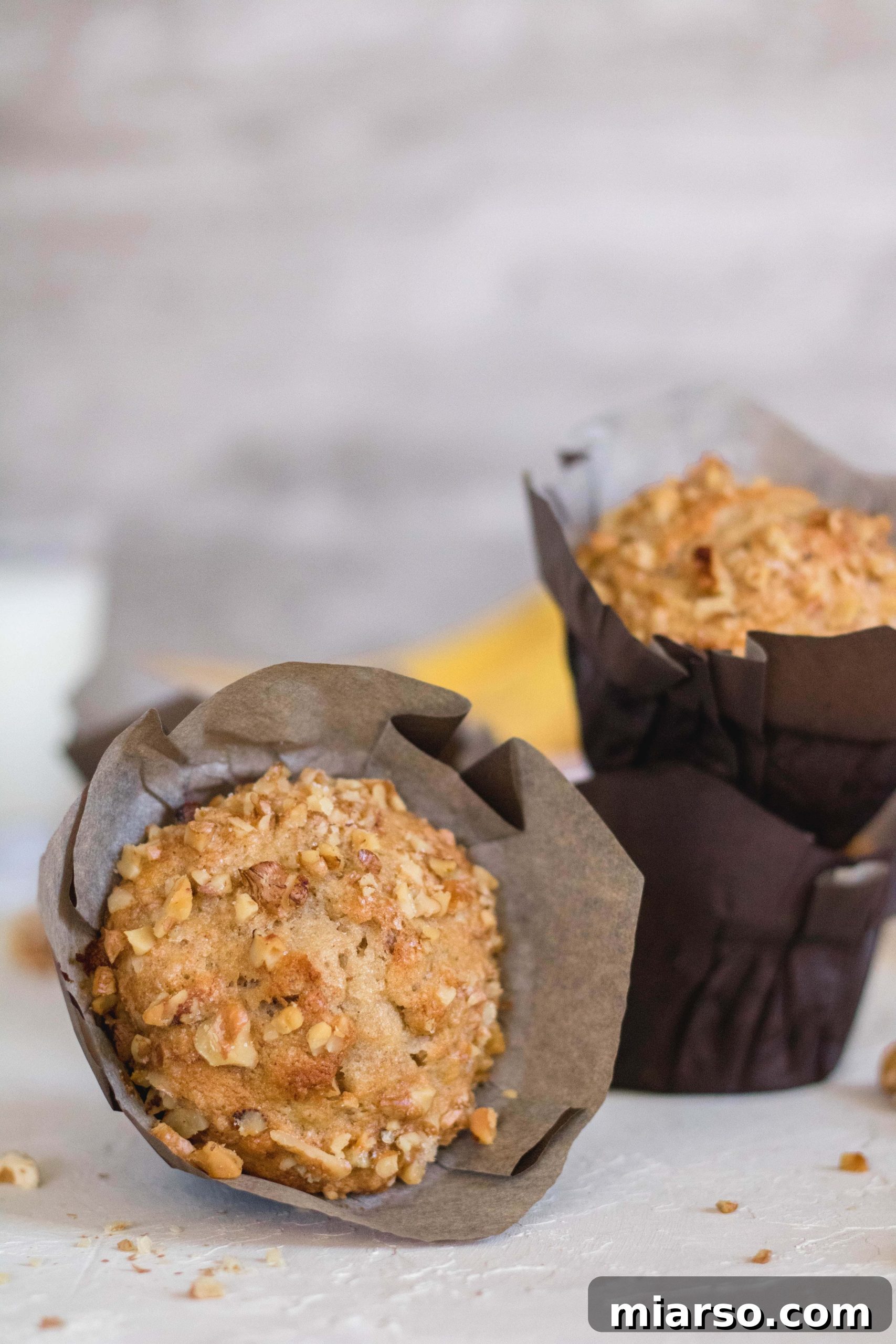 Bakery-Style Banana Walnut Muffins 9 A freshly baked banana walnut muffin, tilted to show its tall dome and texture