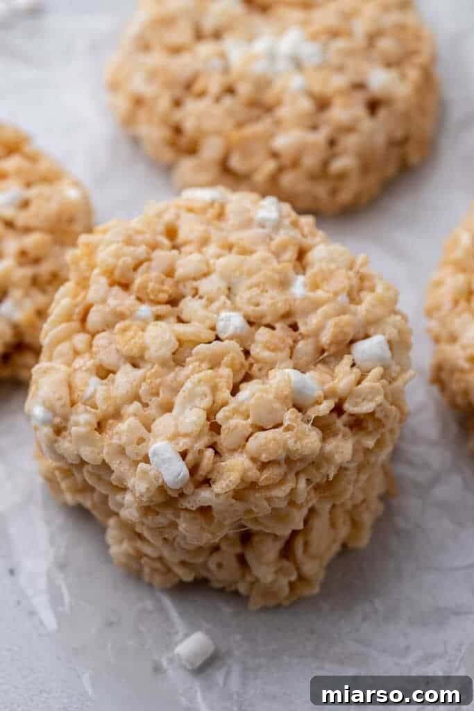 A close-up shot of a Crumbl Rice Krispies bar cookie, showing its rounded shape and crispy texture.