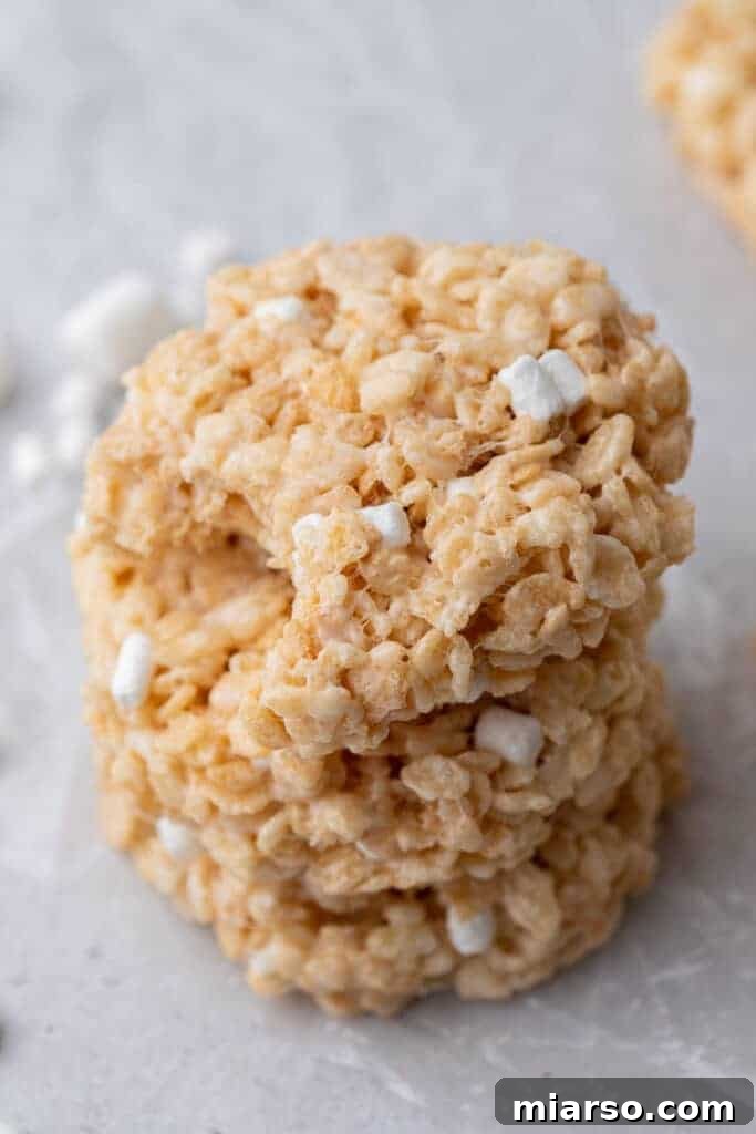A neatly stacked pile of Crumbl Rice Krispie bar cookies, emphasizing their perfect cookie shape and golden color.