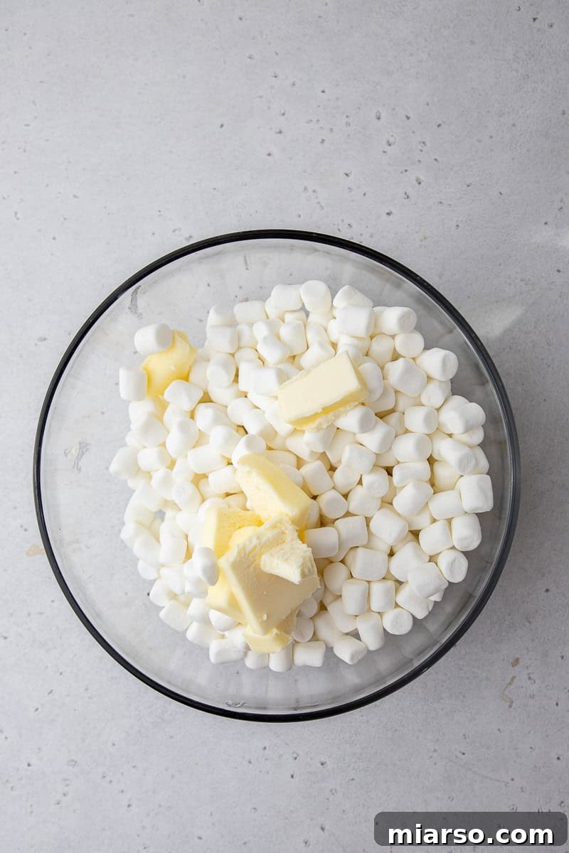 Mini marshmallows and butter melting together in a microwave-safe bowl.