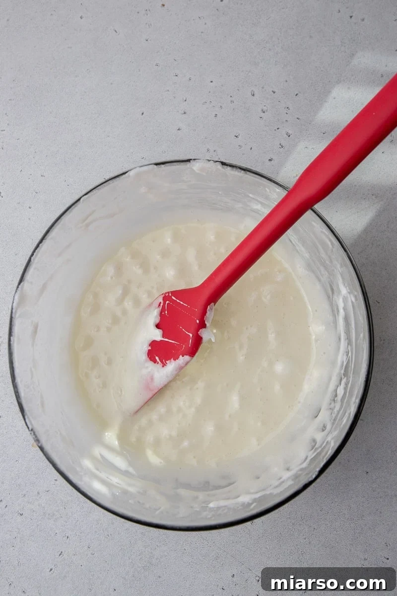 Melted marshmallows and butter, smooth and ready for the next step in a white bowl.