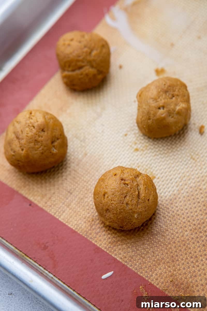 Divine Chocolate Pumpkin Truffle Delights 6 Rolled pumpkin balls on a baking sheet, ready for chilling