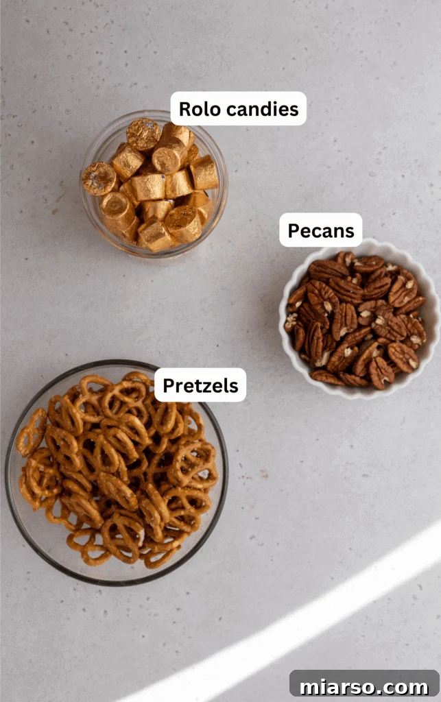 Ingredients for Rolo Pretzel Turtles laid out on a kitchen counter, including pretzels, Rolo candies, and pecan halves.