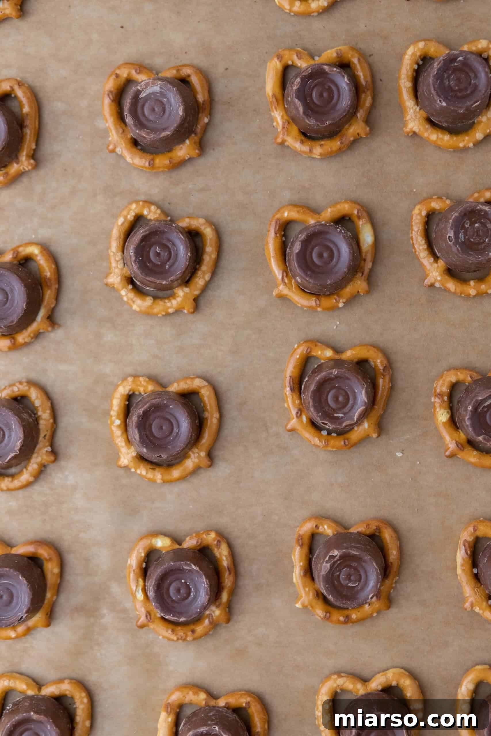 Rolo candies placed on top of each pretzel on a baking sheet.